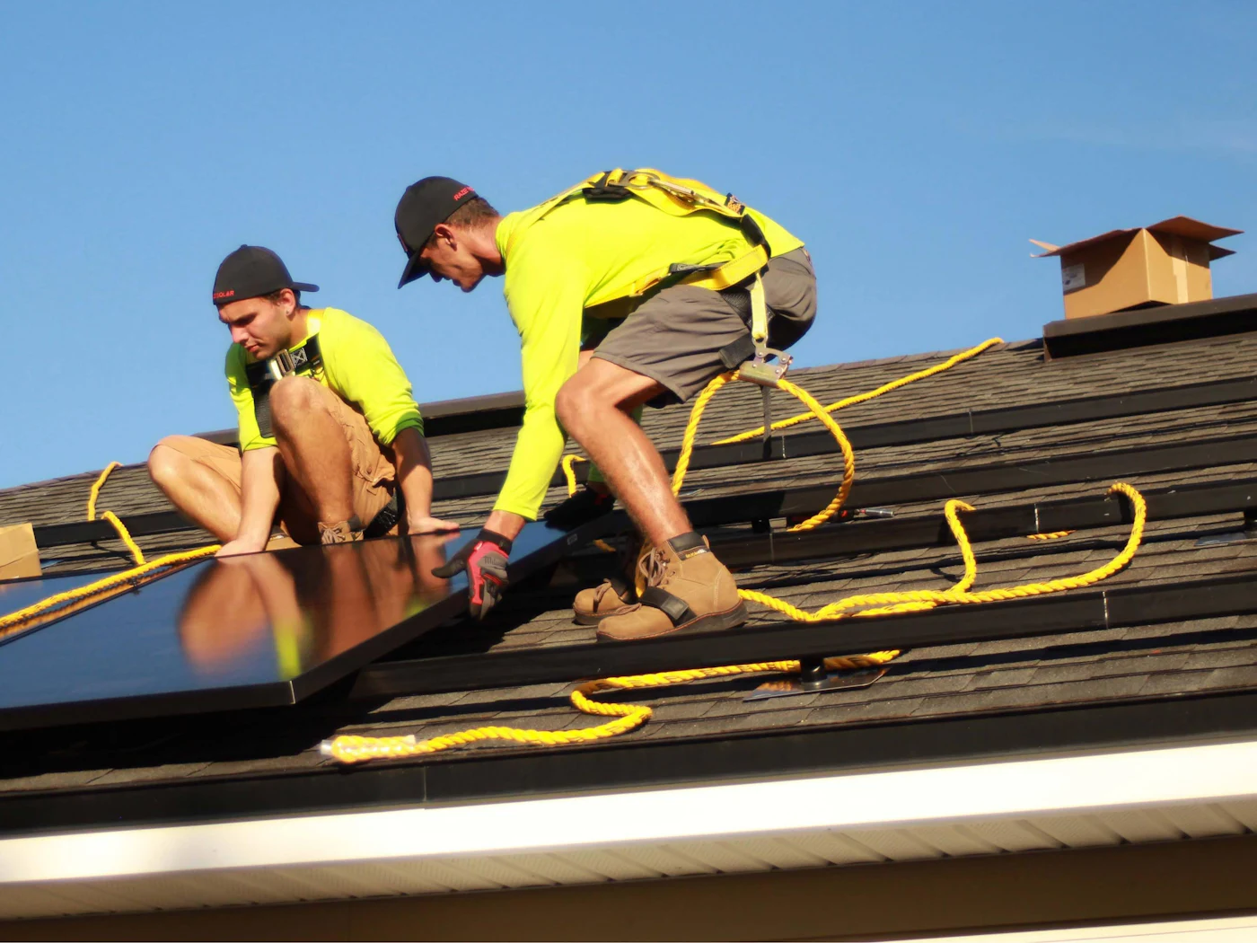 Technicians installing solar modules on a rooftop