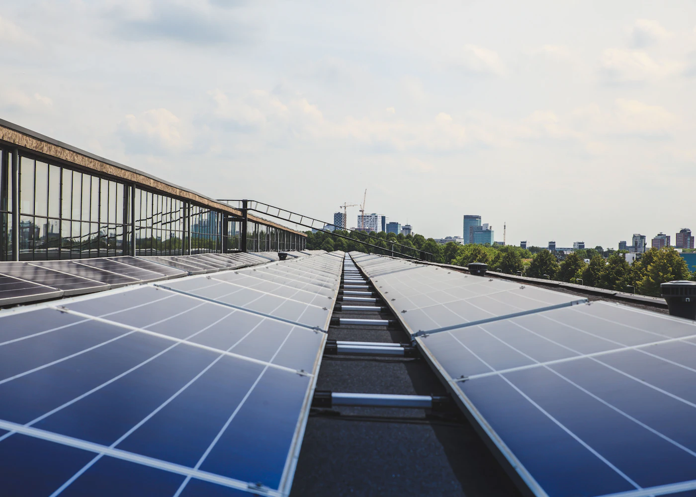 Solar panels on a flat commercial rooftop with city buildings behind