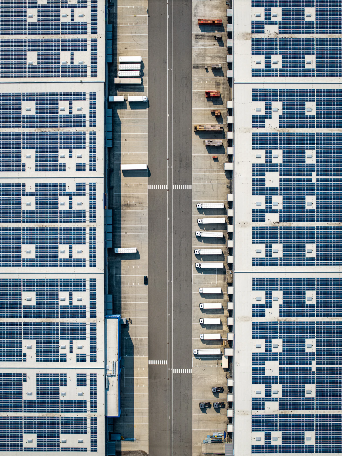 Aerial view of large warehouse roofs covered with solar panels